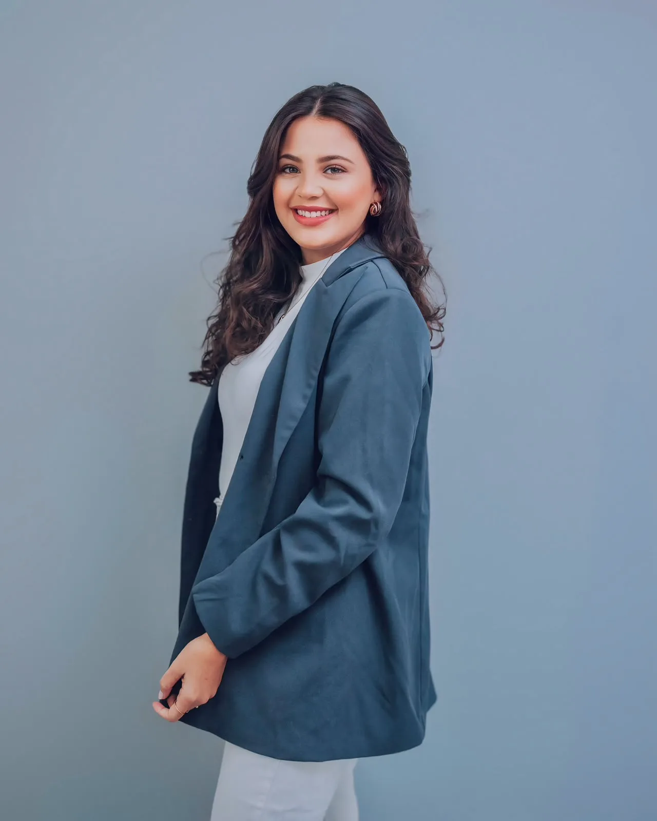 Jany Krisna, psicóloga clínica, sorrindo, de blazer azul